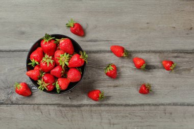 Masa üstü manzaralı, küçük siyah seramik kaseli, çilekli, biraz da... 