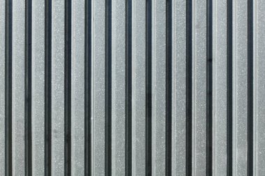 Metal levha çiti, güneş yandan parlıyor. Soyut yapı 