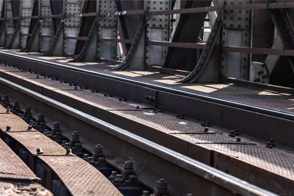 Detail on railway tracks at steel rail bridge lit by sun. — Stock Photo, Image