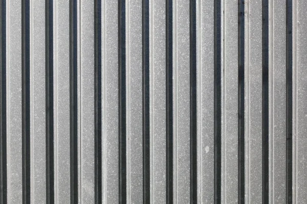 Metallplåtsstängsel, sol skiner från sidan. Abstrakt konstruktion — Stockfoto