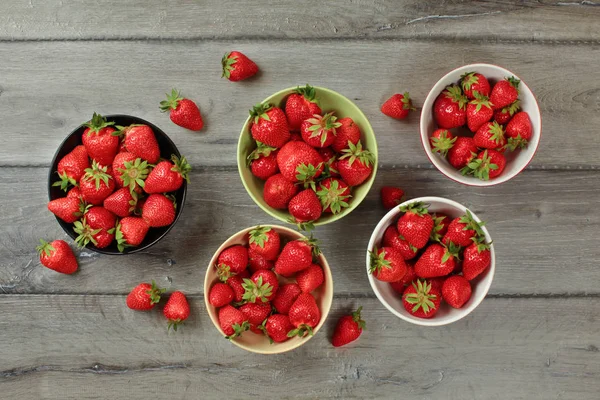 Vista de la mesa, cuencos pequeños con fresas, algunos de ellos derraman — Foto de Stock