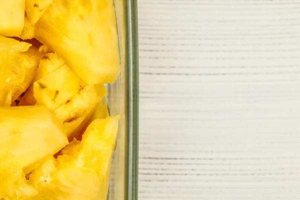 Вид на столешницу, деталь - желтый ананас, разрезанный на куски, в квадрате — стоковое фото