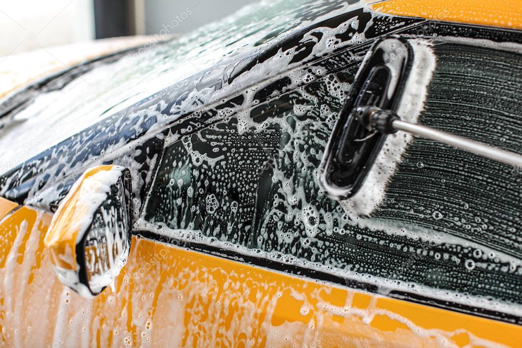 Yellow car side window washed in self service carwash. rush leav