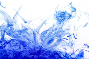 Şırıngadan mavi mürekkep enjekte edilmiş, suyla karıştırılmış soyut şekiller yaratılmış, akvaryum tankından fotoğraf çekilmiş.