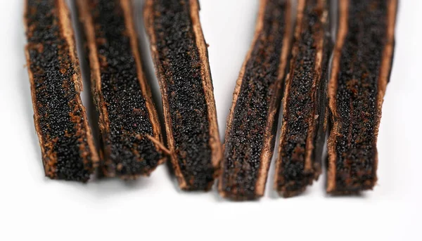 Cialde di vaniglia tagliate con coltello, semi neri visibili, dettaglio primo piano foto isolate su sfondo bianco — Foto Stock