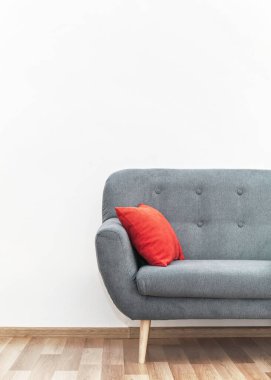 Ahşap döşemeli kırmızı yastıklı modern gri kanepe - ofis mobilyaları, beyaz duvar - yazı için alan - yukarıda