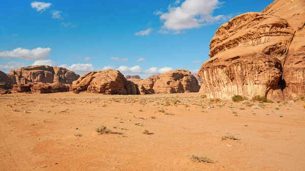 Massiccio roccioso sul deserto di sabbia rossa, cielo azzurro brillante sullo sfondo - scenario tipico di Wadi Rum, Giordania — Foto Stock