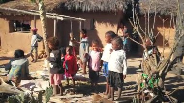 Ilakaka, Madagaskar - 30 Nisan 2019: Bir grup Malagasy 'li çocuk çamurlu evlerinin yanında durup gülümsüyor. Bu bölgedeki insanlar çok fakir ama yine de neşeli.
