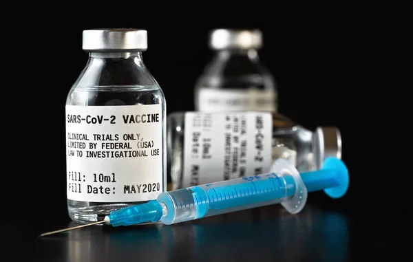 Coronavirus Covid 19疫苗概念 黑桌上的三个玻璃瓶 靠近蓝色皮下注射针 标签本身的设计 虚拟数据 非真正产品 — 图库照片