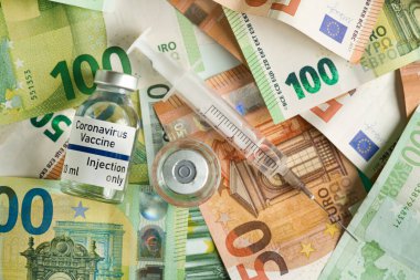 Coronavirus Covid-19 aşı fiyatı / maliyet konsepti - Avro banknotlarının üzerindeki gümüş kapaklı cam şişe, yakınındaki şırınga, kapanış detayı (sahte verili kendi çıkartma tasarımı - gerçek ürün değil)
