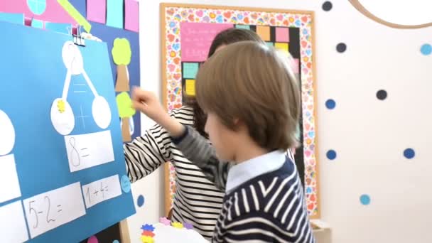 Милый Мальчик Решает Графические Математические Упражнения Детском Саду Наблюдением Педагога — стоковое видео