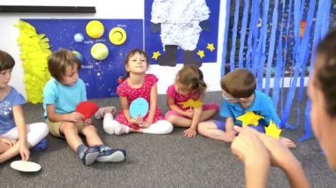 Çocuklar, bir ders olan anaokulu tarafından çevrili eğitimci