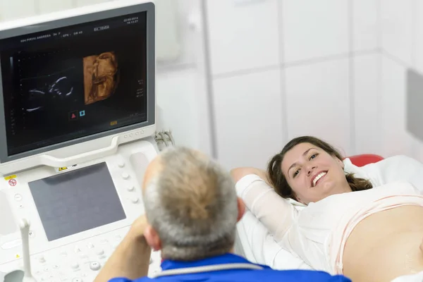 医師のクリニックで妊娠中の女性の腹に 超音波をやっています — ストック写真