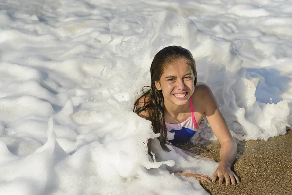 幸せな女の子を敷設 ビーチ 波と日当たりの良い夏の日 周りの泡でリラックス — ストック写真
