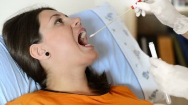 Boğaz ağrısı için sınanan doktor adlı genç bir kadın