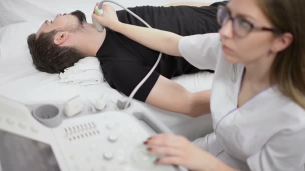正在检查甲状腺在超声设备在一家医院的人 — 图库视频影像