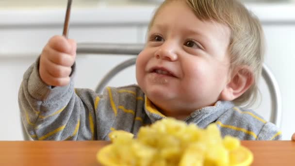 面白いかわいい男の子を食べると台所で笑顔 — ストック動画