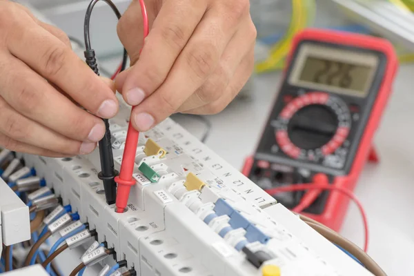 Eletricista testando um painel inteligente elétrico — Fotografia de Stock