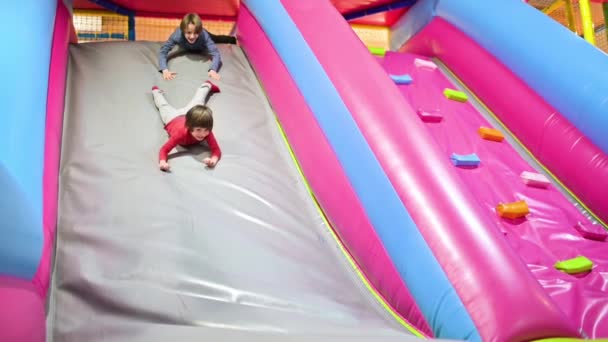 Lustige Jungen Spielen Auf Aufgeblasener Rutsche Indoor Spielplatz — Stockvideo