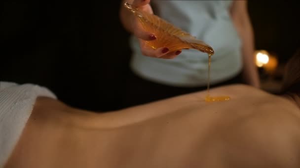 年轻的美女得到蜂蜜按摩在治疗室 — 图库视频影像