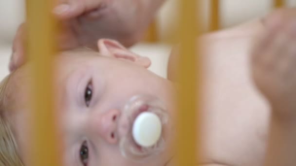 Μωρό Κλαίει Στο Παχνί Στο Σπίτι Και Χαϊδεύεται Από Μητέρα — Αρχείο Βίντεο