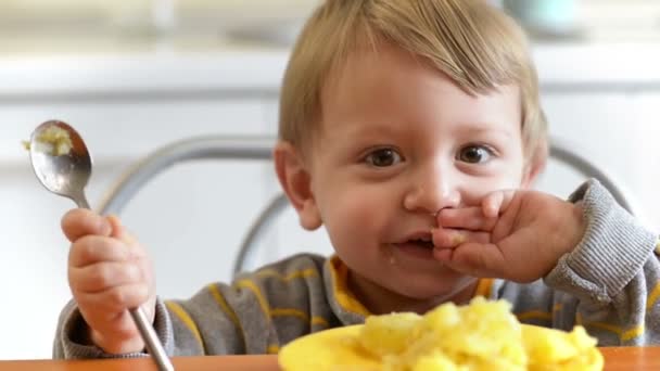 キッチンで初歩的な笑顔を食べてかわいい男の子 — ストック動画
