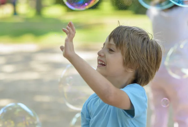 Roztomilé dítě chytat mýdlové bubliny — Stock fotografie