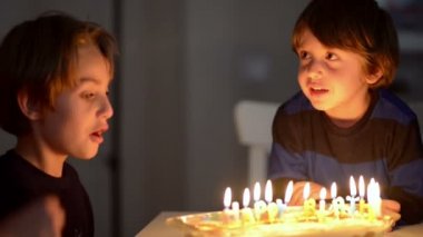 Yıldönümünde mum üfleyen iki mutlu çocuk