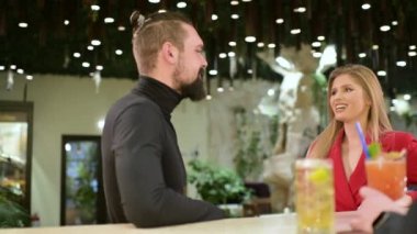 Genç çift bistro barda buluşmaktan zevk alıyor. Barmen kokteyl hazırlıyor.