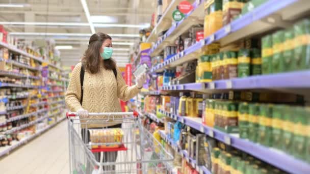 세계적으로 유행하는 시기에 의료용 마스크를 슈퍼마켓에서 쇼핑을 아름다운 — 비디오