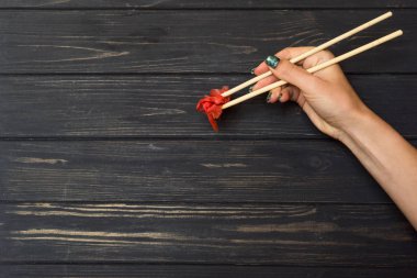 El çubuk turşusu zencefil ile siyah bir ahşap arka plan üzerinde tutar.