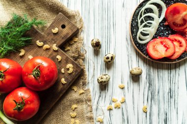 domates, yeşil soğan, dereotu, Yeşiller, makarna, bıldırcın yumurtası Beyaz ahşap bir masa üzerinde kahverengi bir gemide