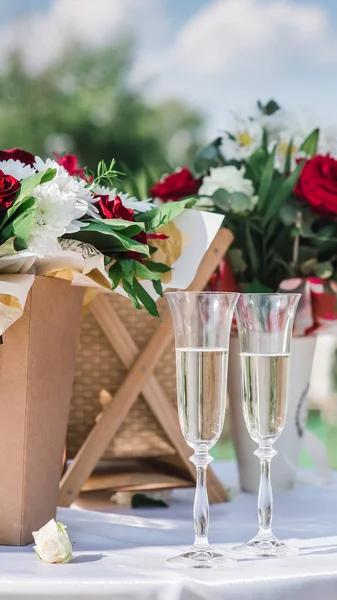 Glas med champagne på ett bröllop på en bakgrund av blommor — Stockfoto