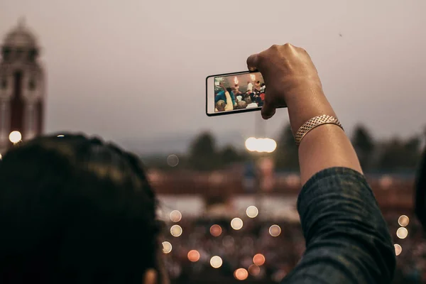 girl takes video and photos from the ceremony near the river on the phone