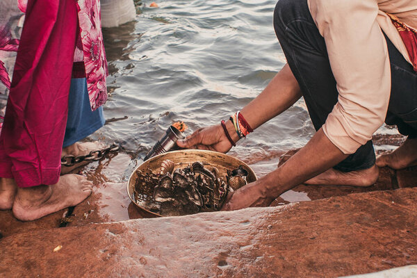 в реке в Азии люди с босыми ногами готовятся к церемонии
