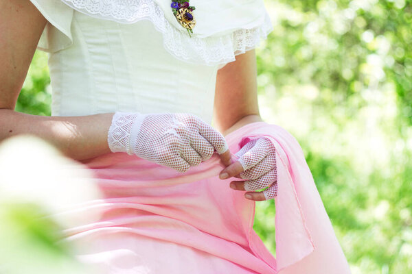 Vintage bride in gloves in a white-pink dress with a retro brooch 1