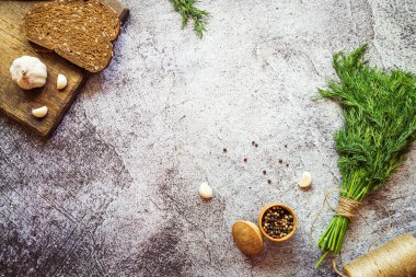 Ekmek, sarımsak kahverengi tahta, dereotu ve biber karışımı gri beton arka planda