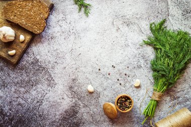 Ekmek, sarımsak kahverengi tahta, dereotu ve biber karışımı gri beton arka planda