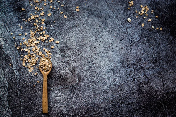 Yulaf ezmeli ahşap kaşık gri beton arka planda yatıyor.