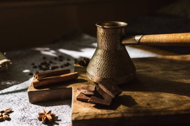 Kahverengi tahta üzerinde kahve, tarçın, çikolata ve baharat yapımında kullanılan malzemeler.