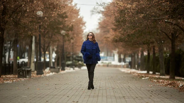 The girl walks through the city in a fur coat — Stock Photo, Image