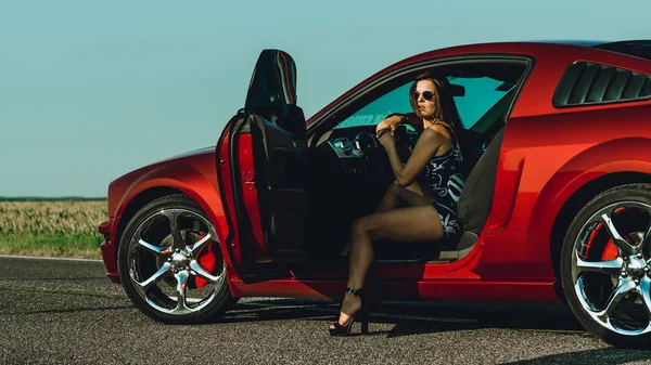 Beautiful Girl Bodysuit Long Hair Sunglasses Sits Hood Red Car — Stock Photo, Image