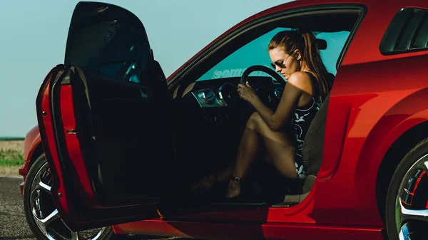 Beautiful Girl Bodysuit Long Hair Sunglasses Sits Hood Red Car — Stock Photo, Image