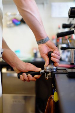 Barista kapuçino yapıyor, barmen kahve hazırlıyor.