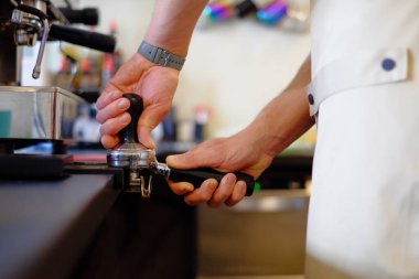 Barista kapuçino yapıyor, barmen kahve hazırlıyor.