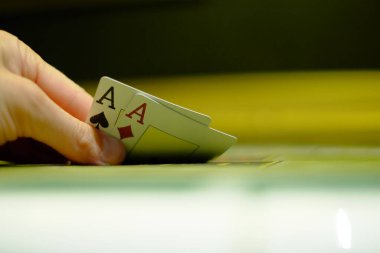 Kumar poker oyunu, oyuncu bir çift as ve kumarhane içi yeşil poker masasının kombinasyonunu açar.