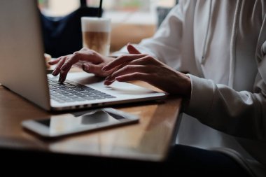 Kafede dizüstü bilgisayar kullanan bir iş kadını. Genç ve güzel bir kız bir kafede oturuyor ve bilgisayarla çalışıyor.