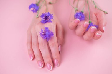 Mavi çiçekli güzel kadın elleri, beyaz arka planda izole edilmiş kadın vücudu, Spa, doğal el kozmetikleri, lüks güzellik salonu ve kaplıca, manikür ve masaj konsepti.