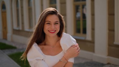 Beyaz elbiseli güzel kız şehirde dolaşıyor.