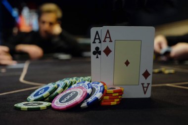 Krupiye ya da krupiye kumarhanedeki poker kartlarını masanın arka planında karıştırıyor. Poker konsepti, oyun işi. Para için oynamak, büyük bir galibiyet, büyük ikramiye, kumar, zengin olma arzusu..